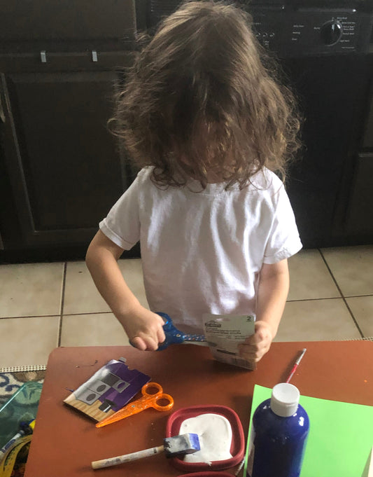 Neurodivergent child learning to use scissors.