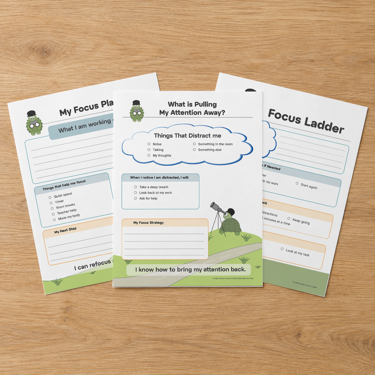 Three Focus Toolkit worksheets fanned on a wooden table.